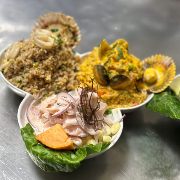 Three Peruvian seafood dishes: ceviche, arroz con mariscos, and arroz chaufa de mariscos, on a metal surface.