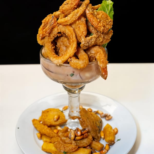 Peruvian Jalea Mixta with crispy fried seafood, calamari, shrimp, and fish, served with corn and plantains.